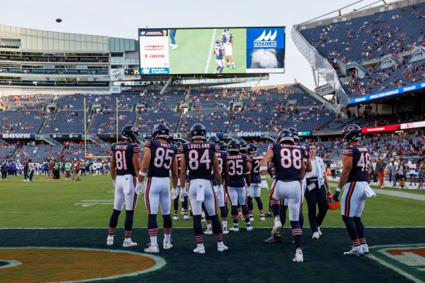 Chicago Bears players warm up on the field before the...