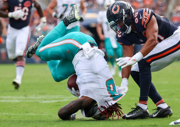 Miami Dolphins running back Alexander Mattison (8) lands on his head while being tackled by Chicago Bears defensive back Alex Cook (30) in the fourth quarter of a game at Soldier Field on Aug. 10, 2025, in Chicago. Cook was injured during the play. (Stacey Wescott/Chicago Tribune)
