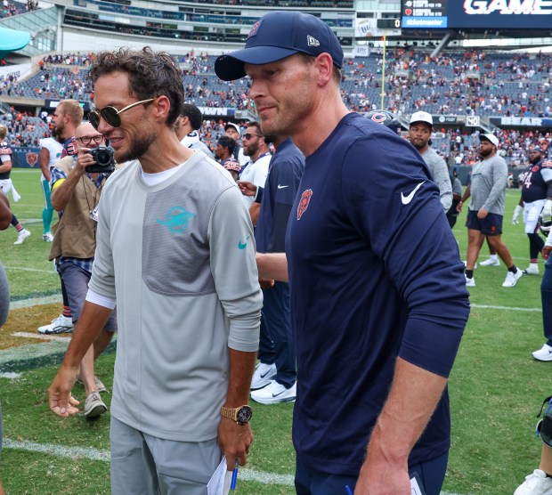 Chicago Bears head coach Ben Johnson, right, pats Miami Dophins coach Mike McDaniel on the back after the two team tied 24-24 in their first preseason game of the 2025 season at Soldier Field on Aug. 10, 2025, in Chicago. (Stacey Wescott/Chicago Tribune)
