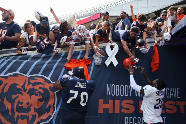 Chicago Bears offensive tackle Braxton Jones (70) and cornerback Tyrique Stevenson (29) sign autographs for fans at the end of Chicago Bears Family Fest at Soldier Field on Sunday, Aug. 3, 2025. (Eileen T. Meslar/Chicago Tribune)