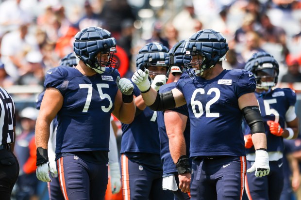 Chicago Bears offensive tackle Ozzy Trapilo (75) and Chicago Bears guard Joe Thuney (62) give each other a fist bump during Chicago Bears Family Fest at Soldier Field on Sunday, Aug. 3, 2025. (Eileen T. Meslar/Chicago Tribune)