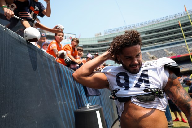 Chicago Bears defensive end Austin Booker (94) fixes his hair after handing a fan his skull cap at the end of Chicago Bears Family Fest at Soldier Field on Sunday, Aug. 3, 2025. (Eileen T. Meslar/Chicago Tribune)