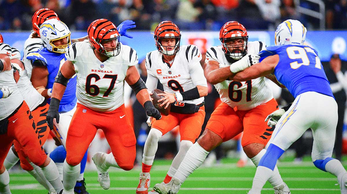 Cincinnati Bengals quarterback Joe Burrow (9) moves out to pass as guard Cody Ford (61) and guard Cordell Volson (67) provide coverage against Los Angeles Chargers linebacker Joey Bosa (97) during the first half at SoFi Stadium.