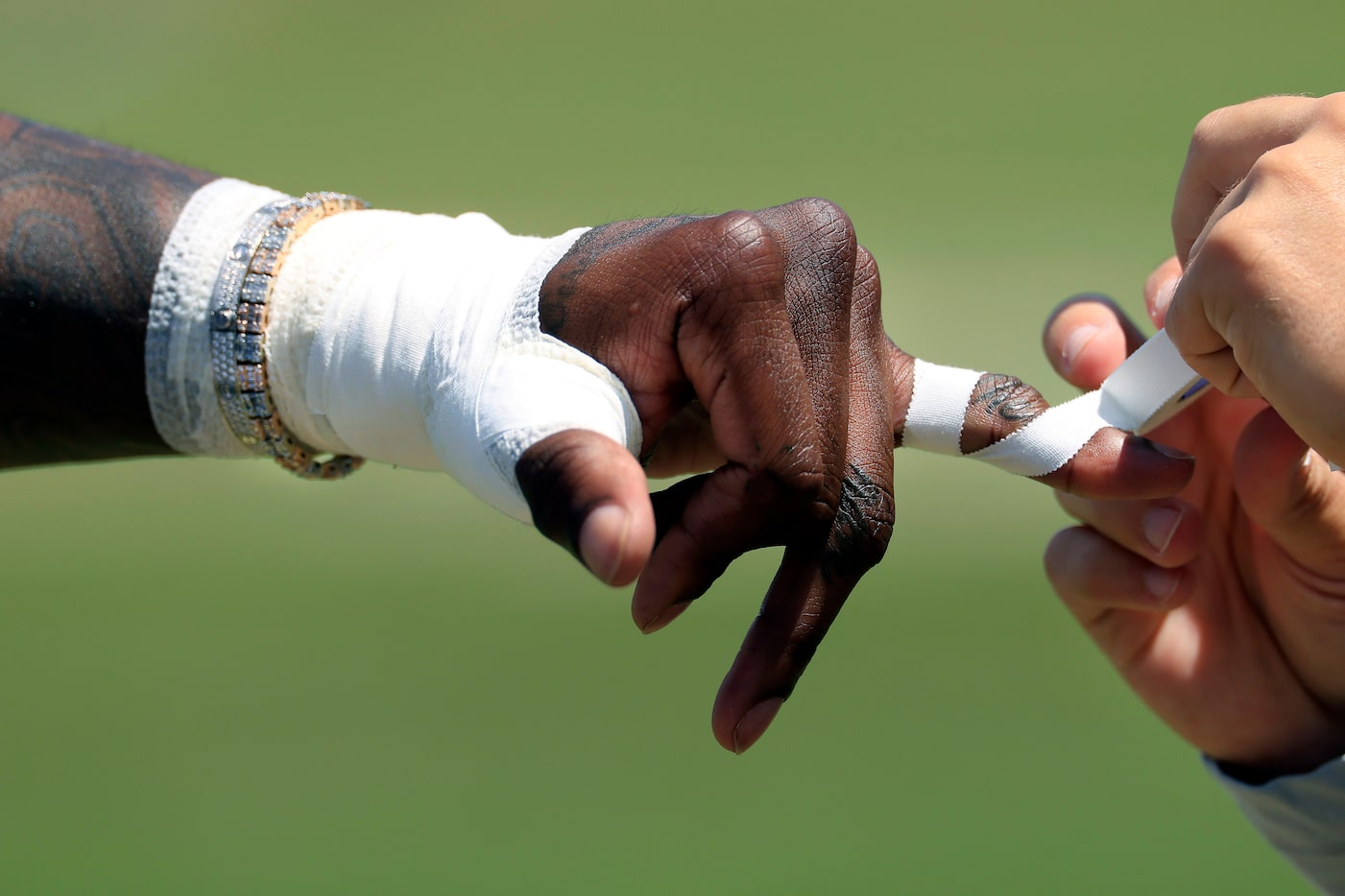 Dallas Cowboys wide receiver CeeDee Lamb  has his fingers wrapped before a training camp...