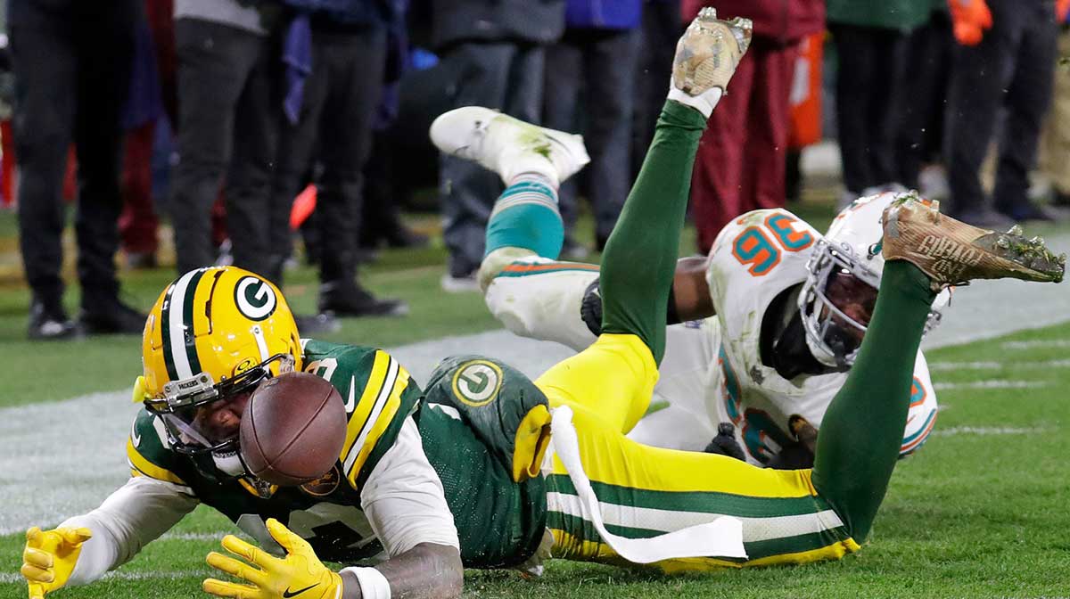Green Bay Packers wide receiver Dontayvion Wicks (13) comes up short on a diving attempt for a touchdown against Miami Dolphins cornerback Storm Duck (36) during their football game Thursday, November 28, 2024, at Lambeau Field in Green Bay, Wisconsin.