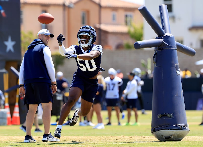 Dallas Cowboys linebacker Shemar Jones (50) reaches for a blind pass as he runs around a...