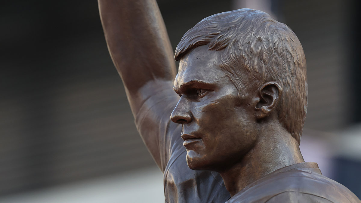 Retired New England Patriot Hall of Famer Tom Brady speaks during a statue unveiling before a game against the Washington Commanders at Gillette Stadium