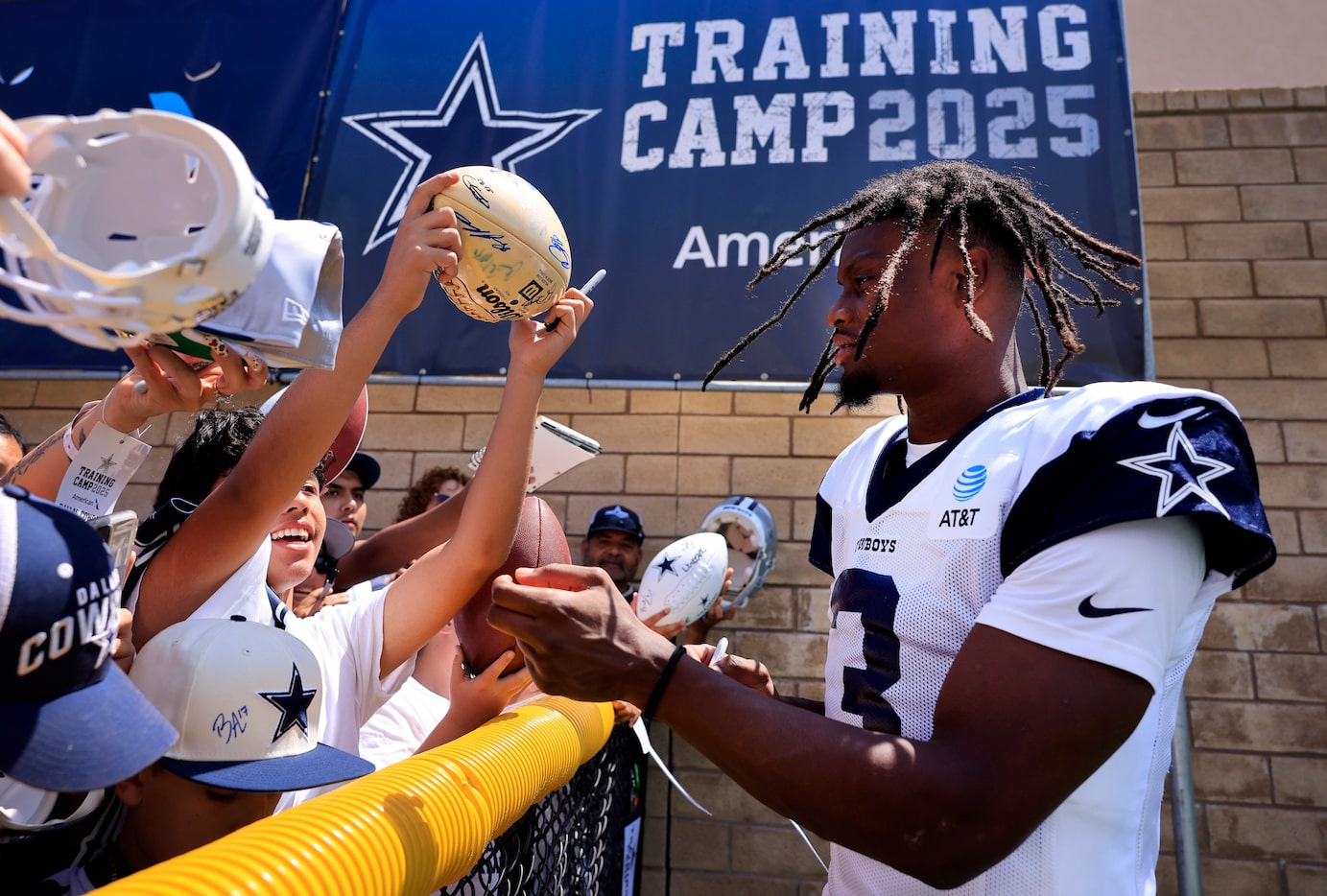 Dallas Cowboys wide receiver George Pickens (3) signs autographs for fans following training...