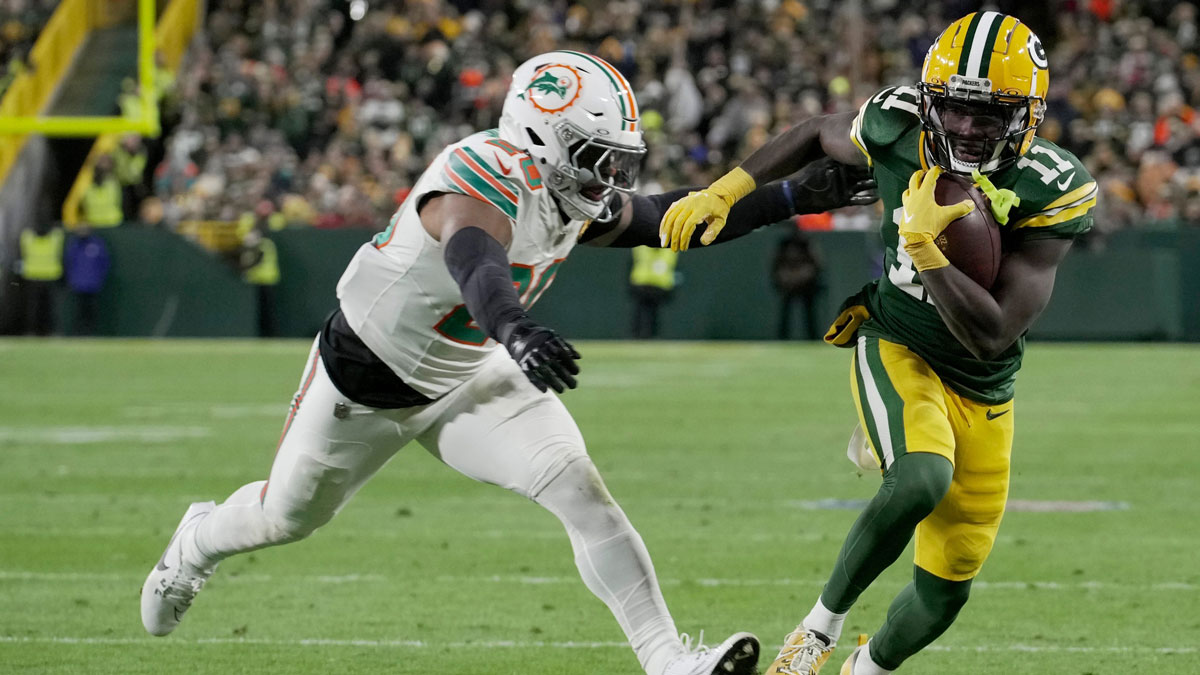 Green Bay Packers wide receiver Jayden Reed (11) outruns Miami Dolphins linebacker Jordyn Brooks (20) to score a touchdown on a reception during the second quarter of their game Thursday, November 28, 2024 at Lambeau Field in Green Bay, Wisconsin.