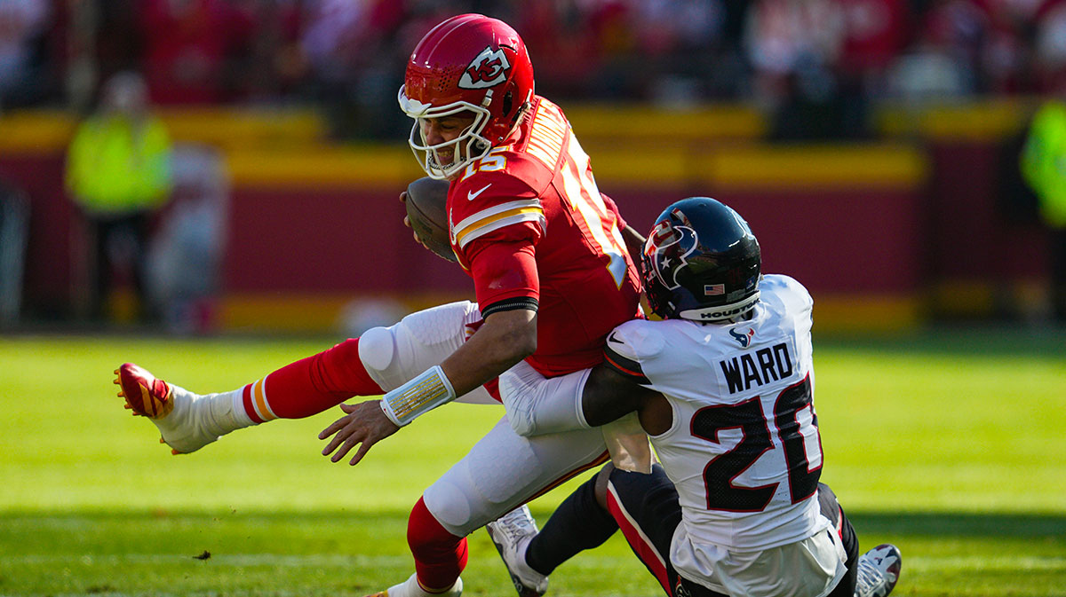 Kansas City Chiefs quarterback Patrick Mahomes (15) is tackled by Houston Texans safety Jimmie Ward (20) during the first half at GEHA Field at Arrowhead Stadium.