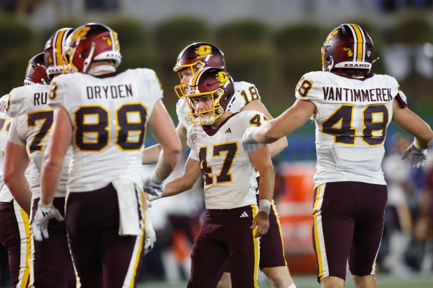 Central Michigan place kicker Cade Graham (47) reacts with teammates...