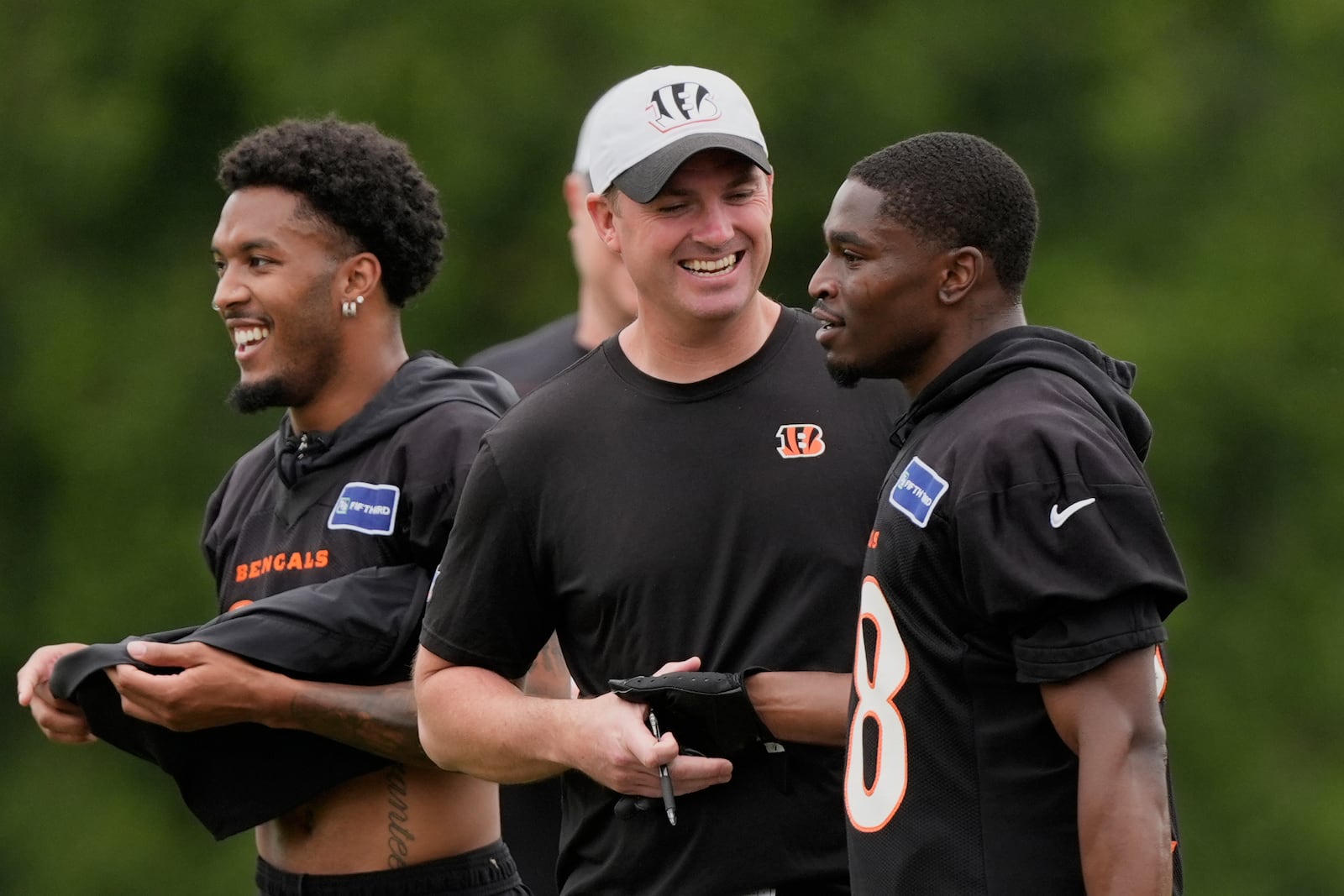 Cincinnati Bengals head coach Zac Taylor talks with Cincinnati Bengals cornerback Josh Newton, right, as cornerback DJ Turner II, left walks behind, during NFL football practice on Tuesday, May 13, 2025, in Cincinnati. (AP Photo/Carolyn Kaster)