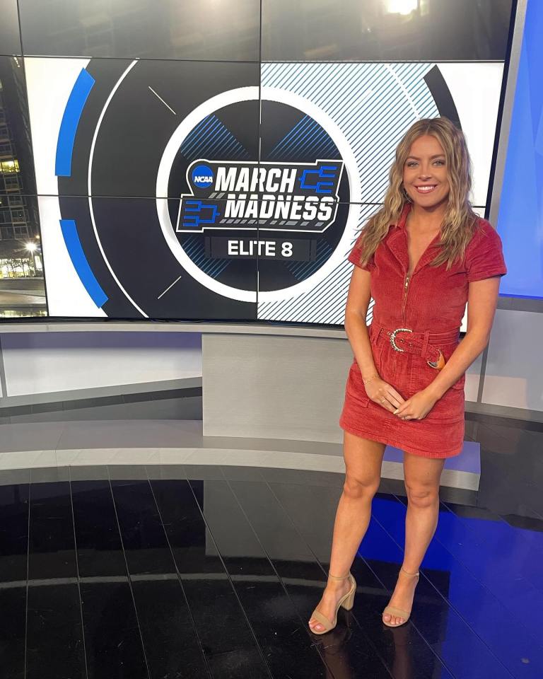 Woman standing in front of an NCAA March Madness Elite 8 screen.