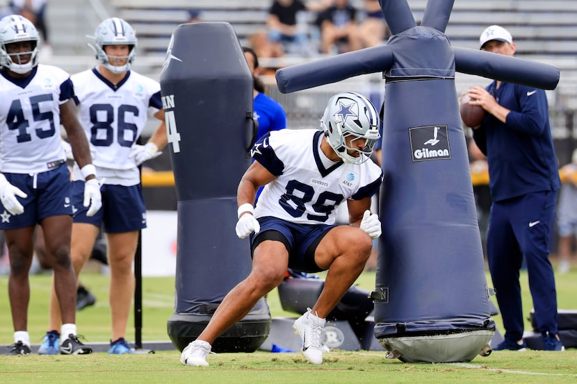 Dallas Cowboys tight end Brevyn Spann-Ford (89) ducks under a blocking dummy before taking a...