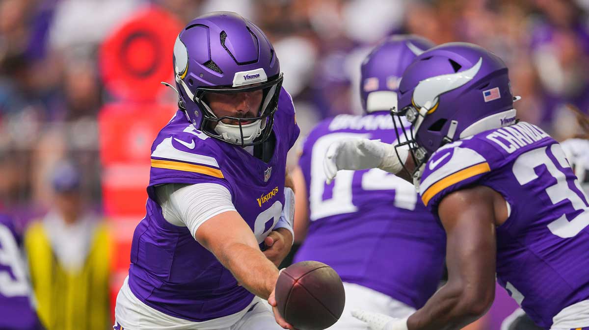 Minnesota Vikings quarterback Sam Howell (8) hands the ball off to running back Ty Chandler (32) against the Houston Texans in the second quarter at U.S. Bank Stadium.
