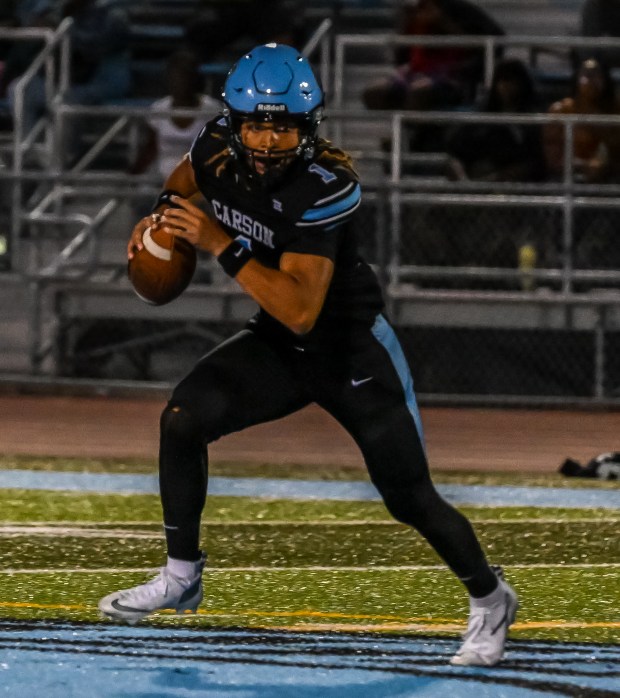 Carson High quarterback Chris Fields rushes the ball during the...