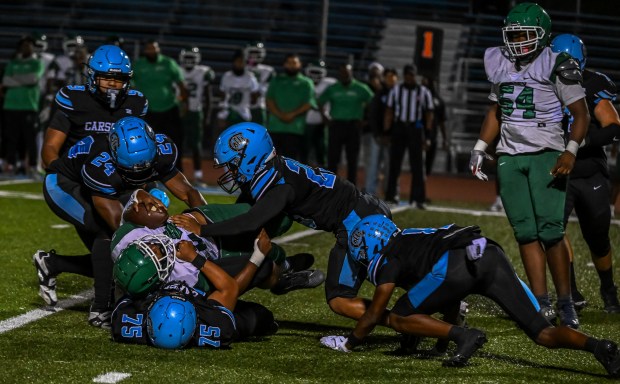 The Carson High defense brings down the runner during the...