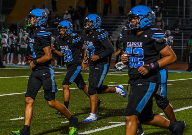 The Carson High offense comes in for a huddle during...