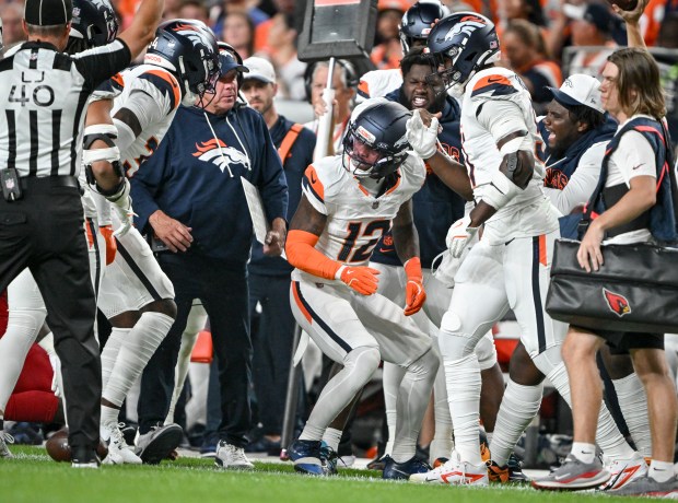 Jahdae Barron (12) of the Denver Broncos is celebrated by teammates after tackling Michael Carter (22) of the Arizona Cardinals during the first quarter at Empower Field at Mile High in Denver on Saturday, Aug. 16, 2025. (Photo by AAron Ontiveroz/The Denver Post)
