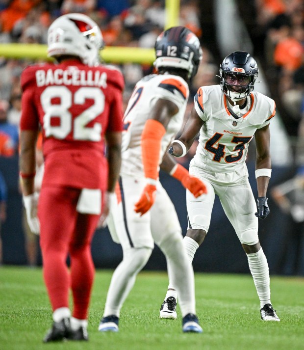 Keidron Smith (43) talks to Jahdae Barron (12) of the Denver Broncos before the snap against the Arizona Cardinals during the first quarter at Empower Field at Mile High in Denver on Saturday, Aug. 16, 2025. (Photo by AAron Ontiveroz/The Denver Post)