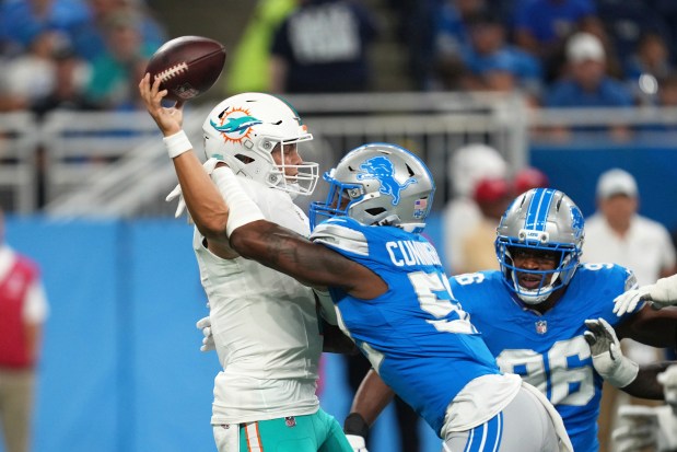 Miami Dolphins quarterback Zach Wilson is hit by Detroit Lions...