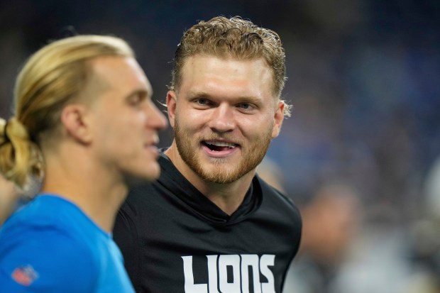 Detroit Lions defensive end Aidan Hutchinson watches players warm up...