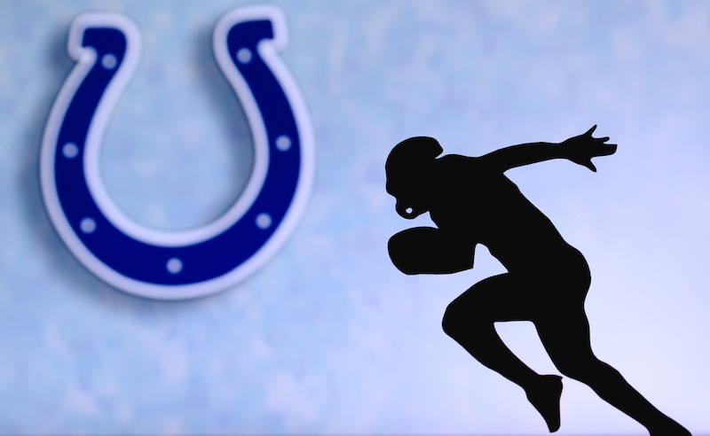 Indianapolis Colts. Silhouette of professional american football player. Logo of NFL club in background, edit space.