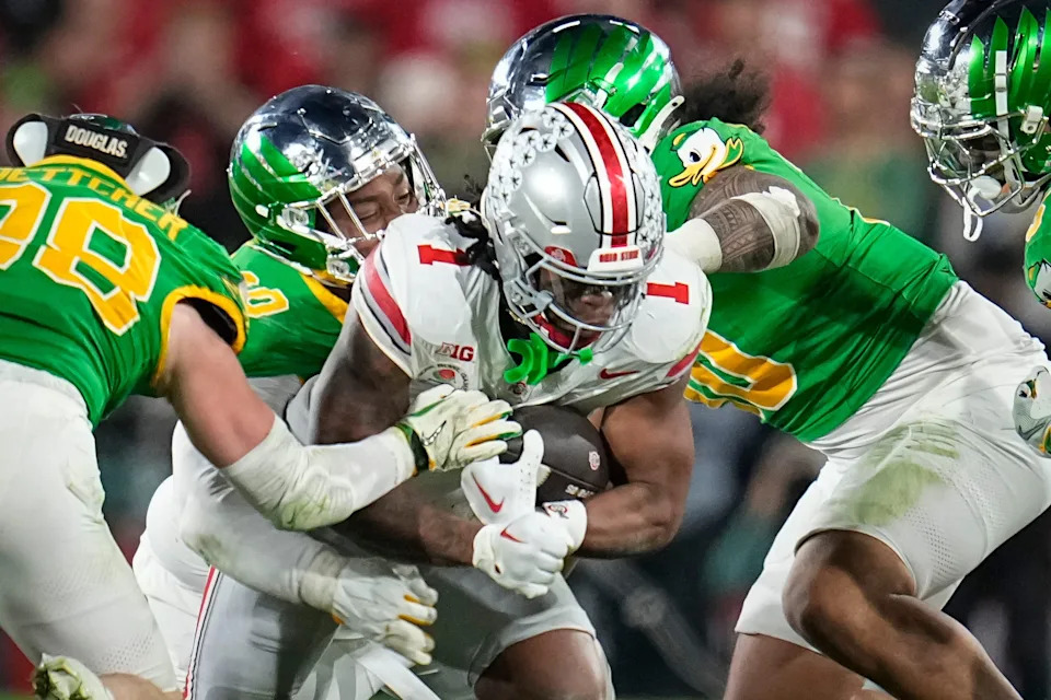 Ohio State Buckeyes running back Quinshon Judkins (1) runs through Oregon Ducks defensive end Matayo Uiagalelei (10) and linebacker Dylan Williams (20) during the College Football Playoff quarterfinal at the Rose Bowl in Pasadena, Calif. on Jan. 1, 2025.