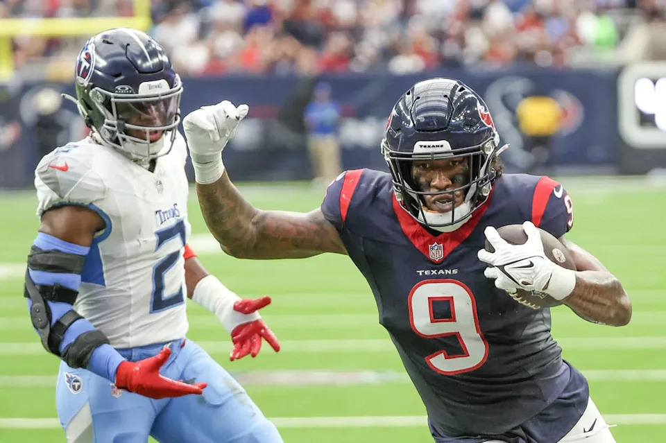 Dec 31, 2023; Houston, Texas, USA; Houston Texans tight end Brevin Jordan (9) scores a touchdown against Tennessee Titans linebacker Azeez Al-Shaair (2) in the second quarter at NRG Stadium. Mandatory Credit: Thomas Shea-USA TODAY Sports