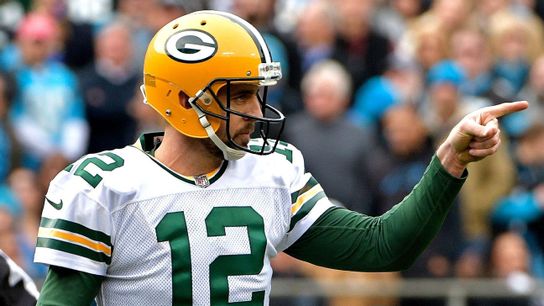 Former Green Bay Packers' quarterback Aaron Rodgers communicating to teammates during a game.