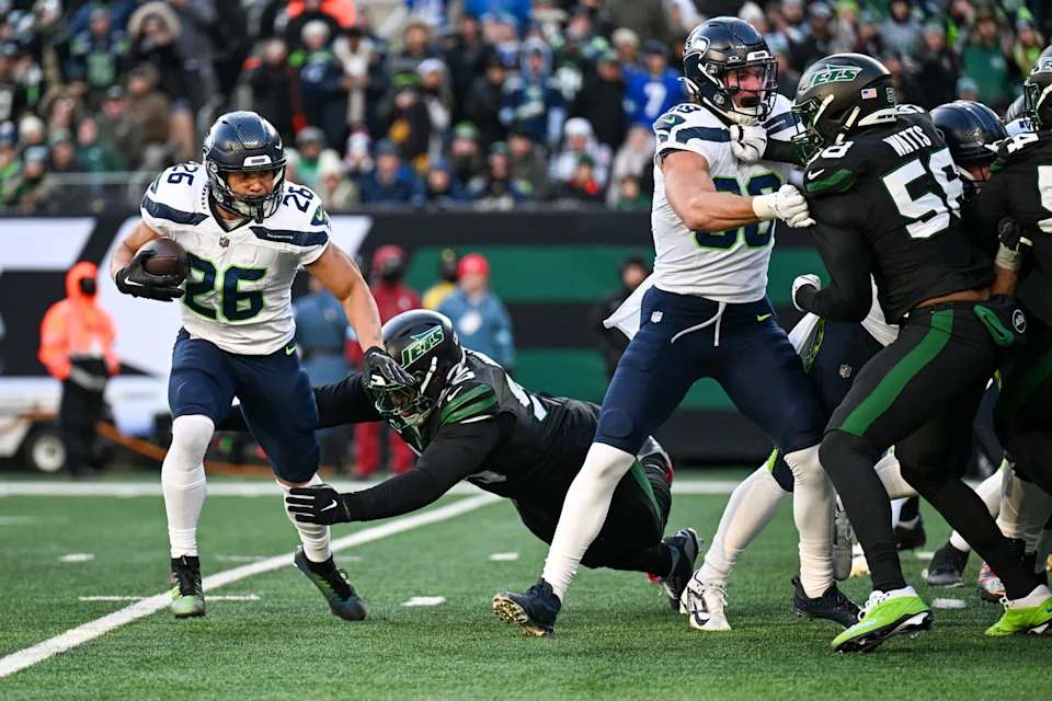 Dec 1, 2024; East Rutherford, New Jersey, USA; Seattle Seahawks running back Zach Charbonnet (26) runs with the ball and avoids a tackle by New York Jets defensive tackle Leonard Taylor III (96) during the third quarter at MetLife Stadium. Mandatory Credit: Mark Smith-Imagn Images