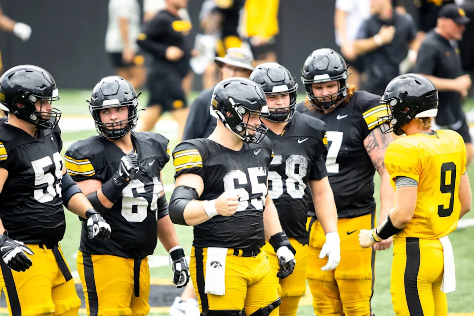 Aug 9, 2025; Iowa offensive linemen Trevor Lauck (59) Leighton Jones (64) Logan Jones (65) Kade Pieper (58) and Gennings Dunker (67) huddle up with quarterback Hank Brown (9) during the Hawkeyes Kids Day NCAA football open practice at Kinnick Stadium in Iowa City, Iowa. Mandatory Credit: Joseph Cress for the Des Moines Register