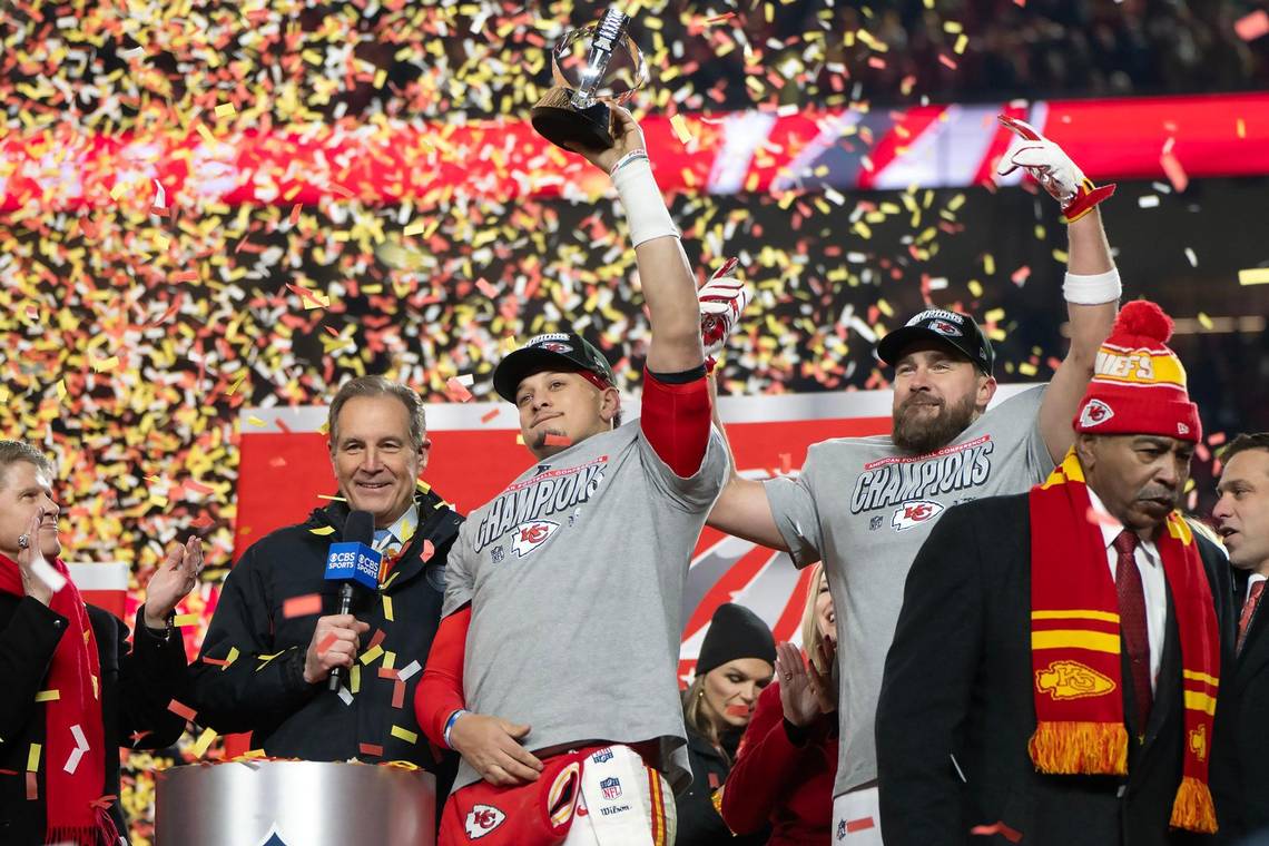 Chiefs owner Clark Hunt and broadcaster Jim Nantz look on as Kansas City Chiefs quarterback Patrick Mahomes holds up a trophy