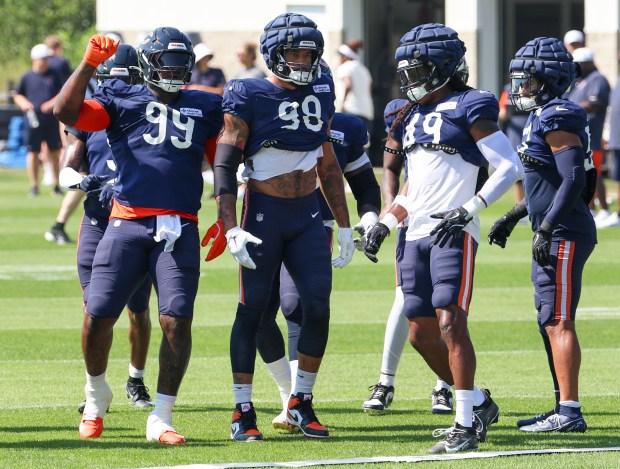 Bears defensive players Gervon Dexter Sr. (99), Montez Sweat (98), Tremaine Edmunds (49) and T.J. Edwards wait for the start of drills during a joint practice with the Dolphins at Halas Hall on Aug. 8, 2025, in Lake Forest. (Stacey Wescott/Chicago Tribune)