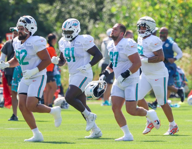 Dolphins defensive players Zach Sieler (92), Matthew Butler (91), Ben Stille (97) and Alex Huntley run across the field during a joint practice with the Bears at Halas Hall on Aug. 8, 2025, in Lake Forest. (Stacey Wescott/Chicago Tribune)