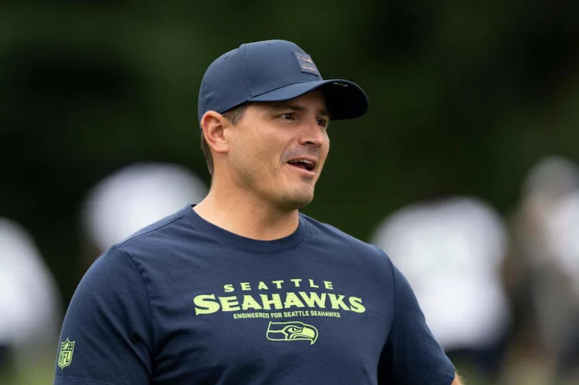 Seattle Seahawks head coach Mike Macdonald talks with players as they warm up during training camp at Virginia Mason Athletic Center on Friday, July 25, 2025, in Renton, Wash.