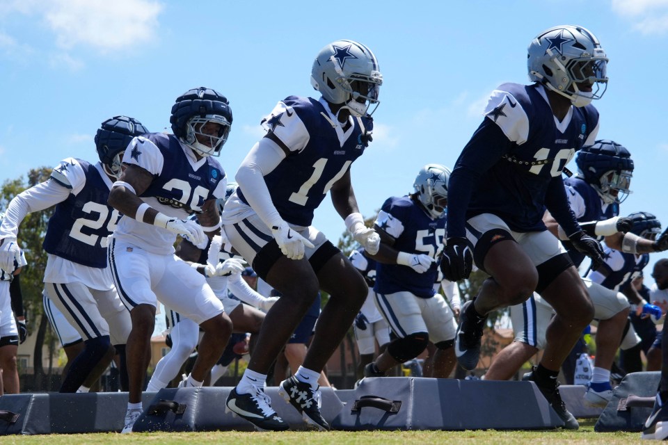 Dallas Cowboys defensive players running drills.