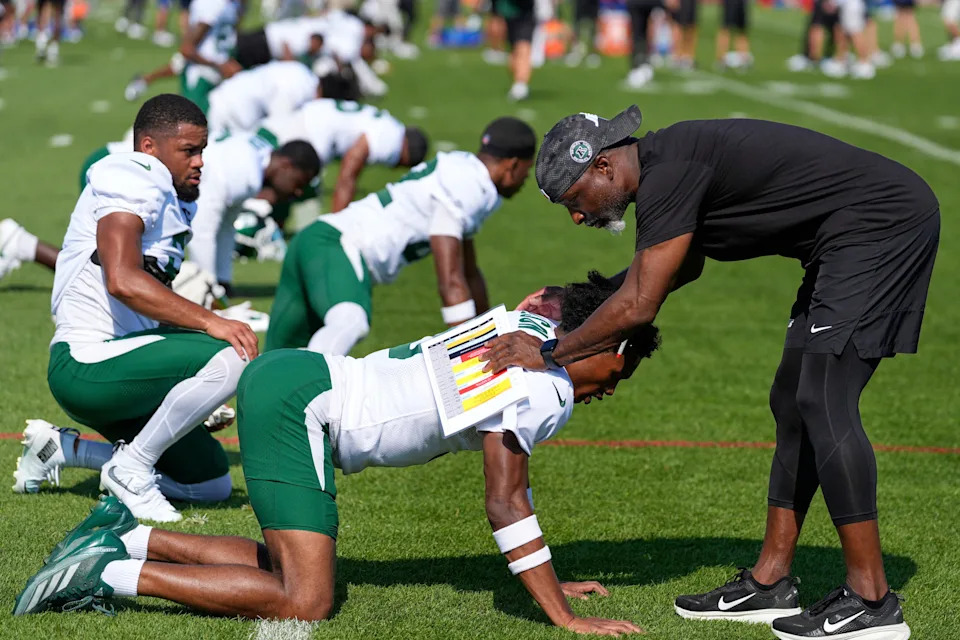 New York Jets' head coach Aaron Glenn, right, greets Garrett Wilson during a joint training camp practice with the New York Giants, Wednesday, August 13, 2025, in East Rutherford, N.J.