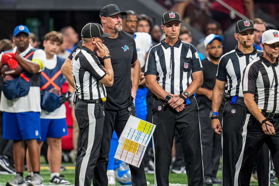 Detroit Lions head coach Dan Campbell speaks with referees.