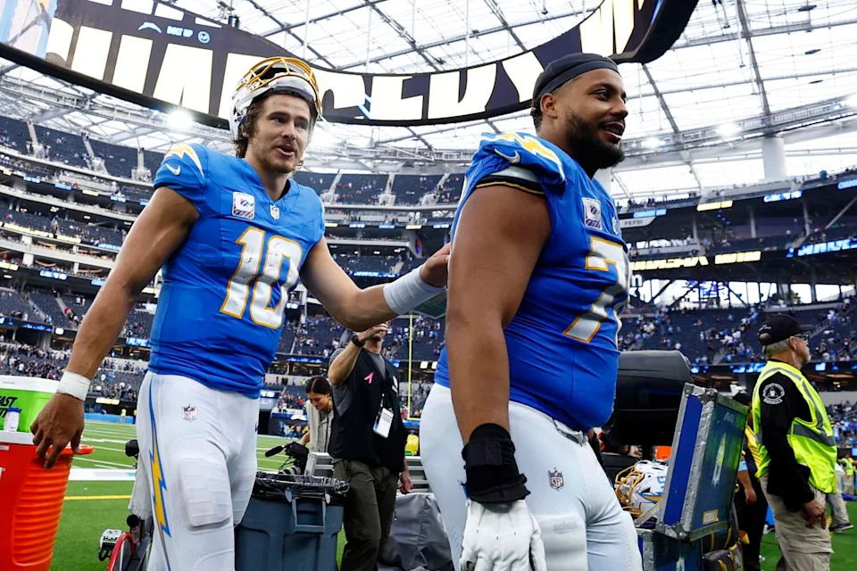 Chargers quarterback Justin Herbert, left, and offensive tackle Rashawn Slater walk off the field.