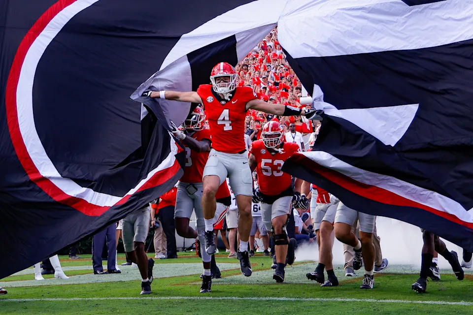 Oscar Delp of the Georgia Bulldogs rips the banner