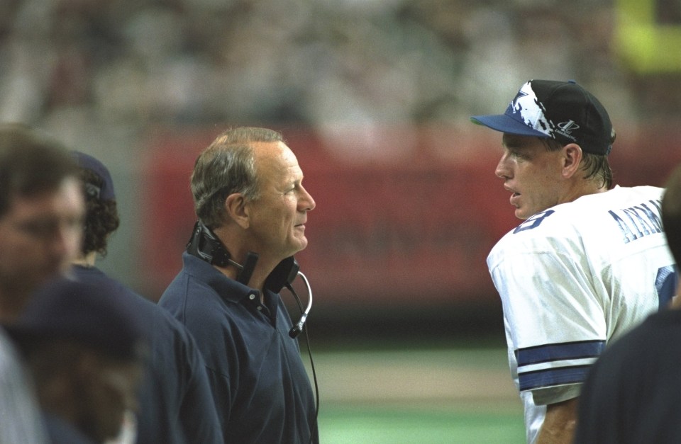 Troy Aikman and Dallas Cowboys head coach Barry Switzer talking on the sidelines.