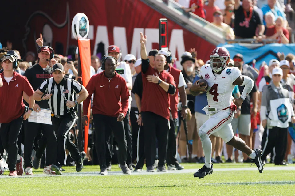 Dec 31, 2024; Tampa, FL, USA; Alabama Crimson Tide quarterback Jalen Milroe (4) runs with the ball while the sideline reacts against the Michigan Wolverines during the second half at Raymond James Stadium. Mandatory Credit: Matt Pendleton-Imagn Images