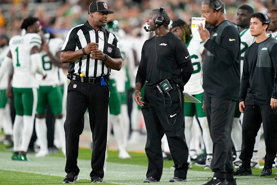 Aug 9, 2025; Green Bay, Wisconsin, USA; New York Jets head coach Aaron Glenn (center) talks with an official during the second half against the Green Bay Packers at Lambeau Field. Mandatory Credit: Kayla Wolf-Imagn Images