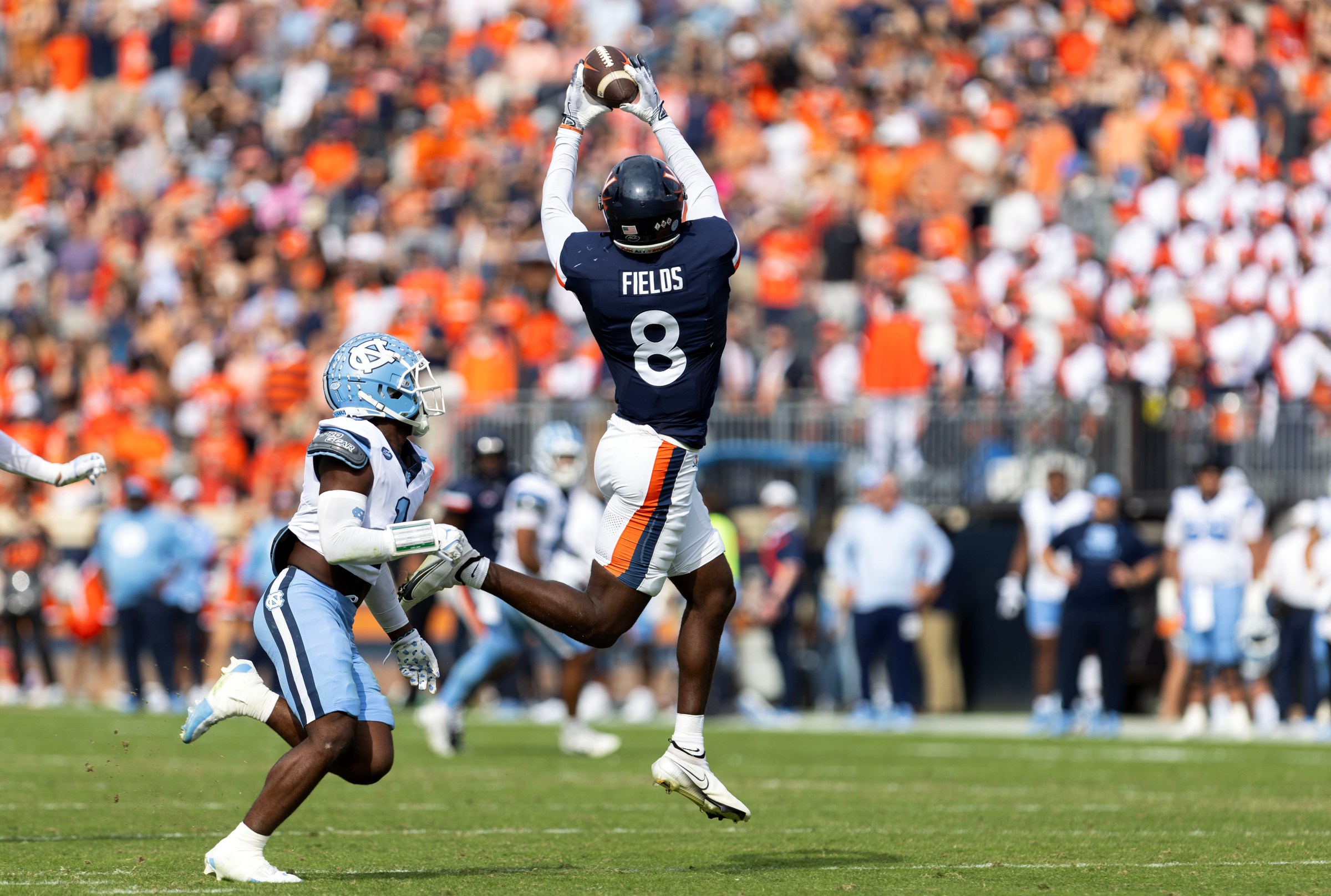 CHARLOTTESVILLE, VIRGINIA - OCTOBER 26: Malachi Fields #8 of the Virginia Cavaliers catches a pass over Antavious Lane #1 of the North Carolina Tar Heels in the first half during a game at Scott Stadium on October 26, 2024 in Charlottesville, Virginia. (Photo by Ryan M. Kelly/Getty Images)