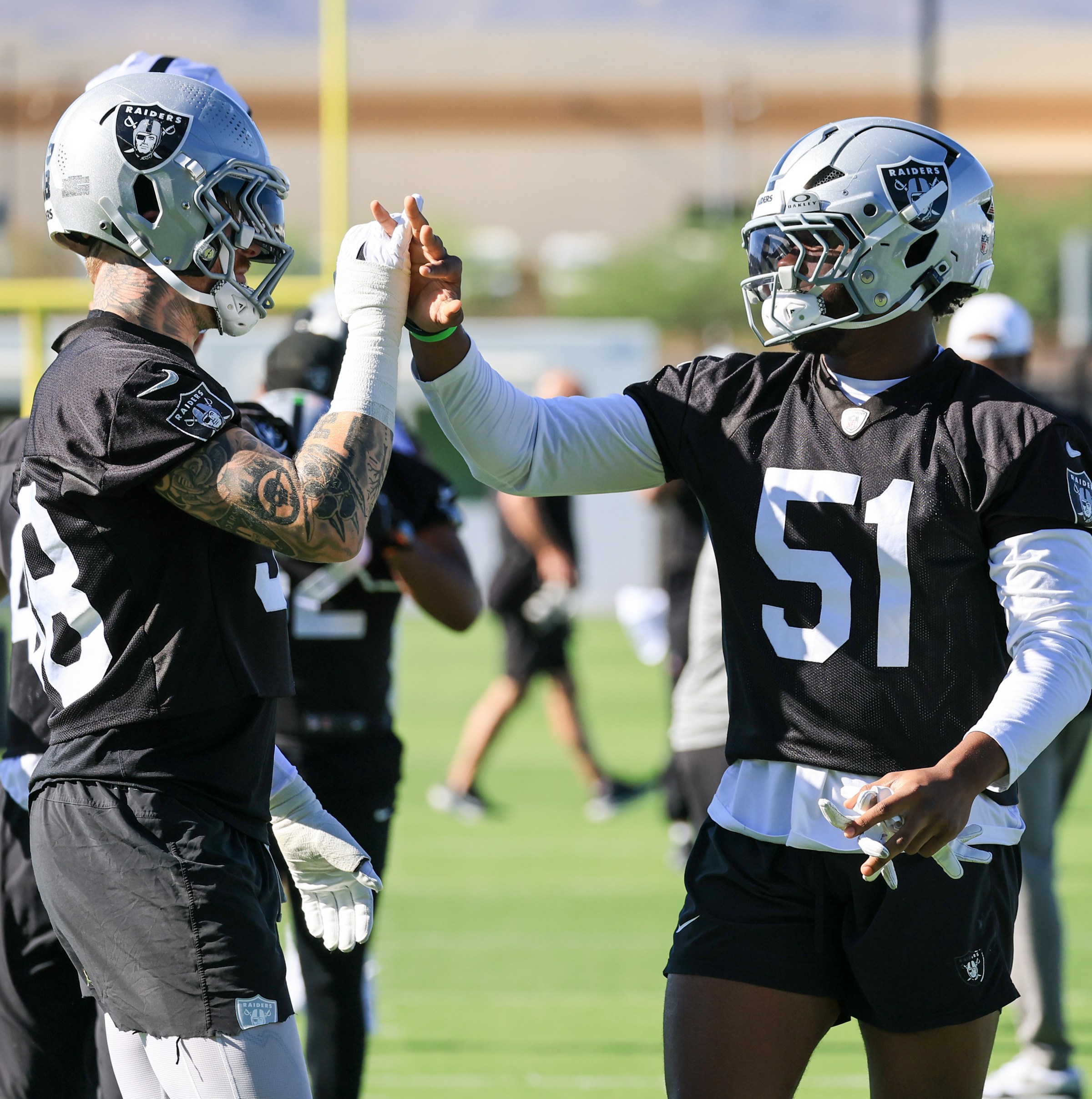 HENDERSON, NEVADA - JULY 23: Maxx Crosby #98 and Malcolm Koonce #51 of the Las Vegas Raiders high-five during the first practice of the team’s training camp at the Las Vegas Raiders Headquarters/Intermountain Health Performance Center on July 23, 2025 in Henderson, Nevada. (Photo by Ethan Miller/Getty Images)