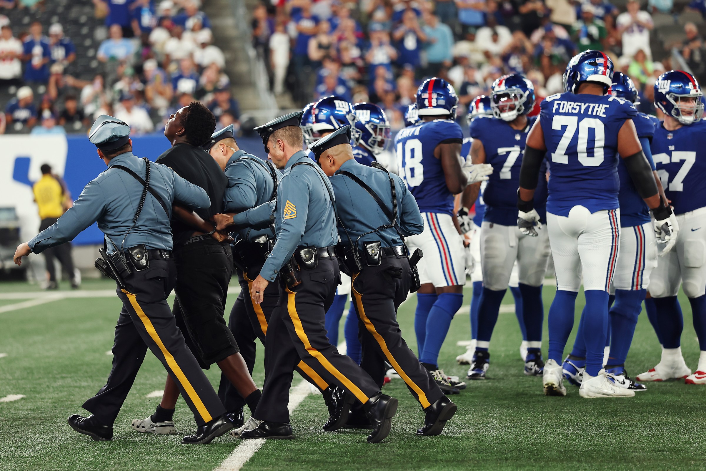 Police escort a fan that ran onto the field during the second half of the NFL Preseason 2025 game between New York Jets and New York Giants at MetLife Stadium on Saturday.