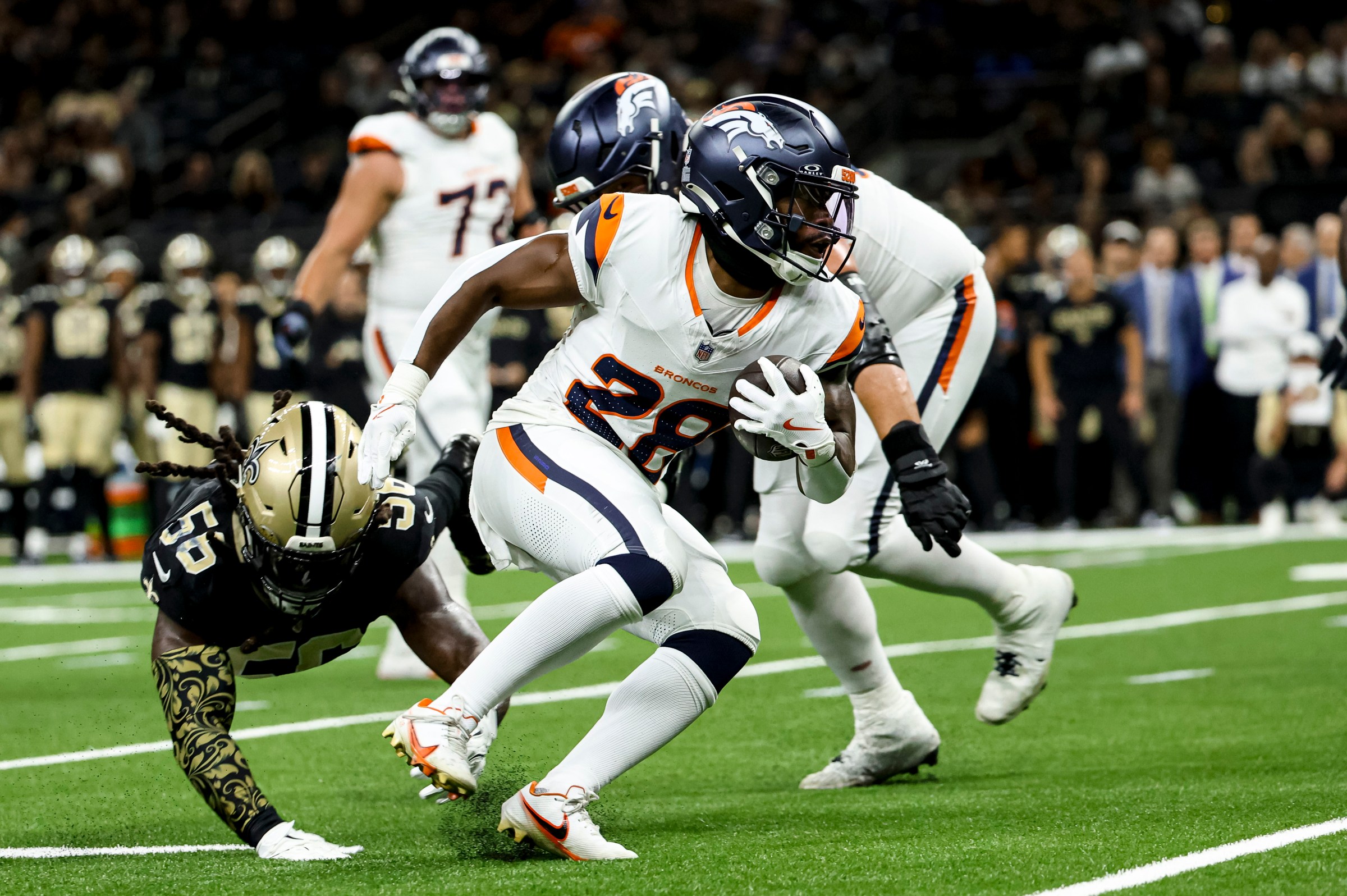 NEW ORLEANS, LOUISIANA - AUGUST 23: Tyler Badie #28 of the Denver Broncos breaks away from Demario Davis #56 of the New Orleans Saints during the first half of a preseason game at the Caesars Superdome on August 23, 2025 in New Orleans, Louisiana. (Photo by Derick E. Hingle/Getty Images)
