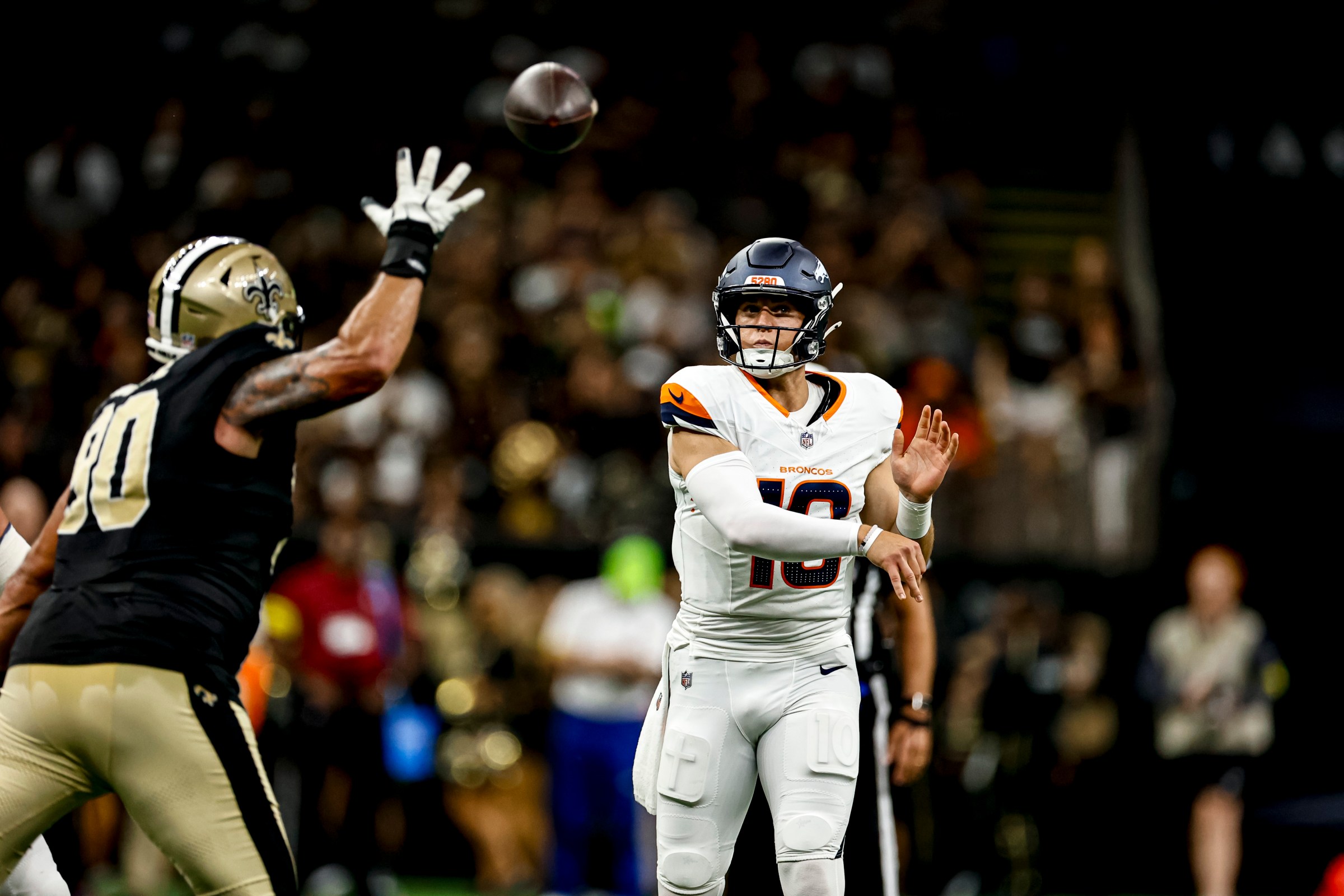 NEW ORLEANS, LOUISIANA - AUGUST 23: Bo Nix #10 of the Denver Broncos throws a pass past Bryan Bresee #90 of the New Orleans Saints during the first half of a preseason game at the Caesars Superdome on August 23, 2025 in New Orleans, Louisiana. (Photo by Derick E. Hingle/Getty Images)