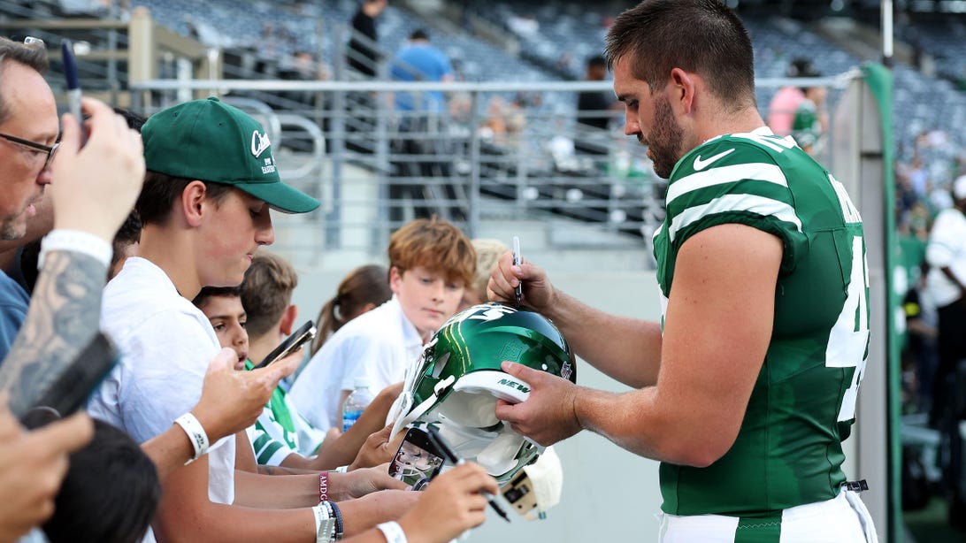 EAST RUTHERFORD, NEW JERSEY - AUGUST 22: Thomas Hennessy #42 of the New York Jets signs autographs before the NFL Preseason 2025 game between Philadelphia Eagles and New York Jets at MetLife Stadium on August 22, 2025 in East Rutherford, New Jersey.